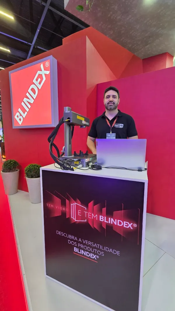 Operador da Self ID com a máquina a laser no estande da Blindex em feira